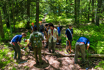 Scouts and adults at work on an Order of the Arrow conservation project in the woods at Ten Mile River Scout Camps, New York, July 8, 2026
