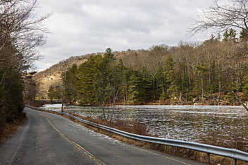 A road runs along the shore of a lake under a gray winter sky in Harriman State Park, January 4, 2025