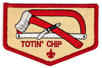 Totin' Chip patch of Scouting America: an ax, a bow saw and a pocketknife above the words Totin' Chip, on a tan shield with a red border