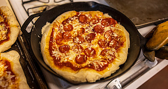 A pepperoni pizza baked in a cast-iron pan on a stove, Troop 23 Brooklyn's February 2026 winter weekend at Ten Mile River