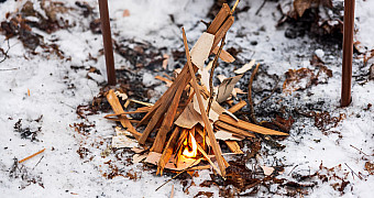 Kindling Catching on a Winter Campout A small tepee of split kindling over wood shavings just catching fire in the snow, winter campout at Massawepie Scout Camps