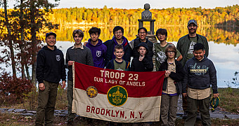 Troop 23 Brooklyn Scouts and leaders with the troop flag on the shore of Crystal Lake at the Lakeside Lean-Tos, Ten Mile River Scout Camps, October 2025