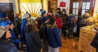 Scouts in winter coats gather around a display inside the Conference House Park Visitor Center, Staten Island, before a morning of service, January 2026