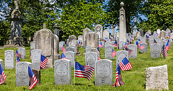 Small American flags at rows of white headstones of Civil War soldiers in Green-Wood Cemetery, Brooklyn, a week before Memorial Day 2025