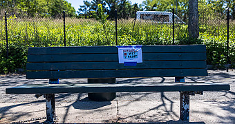 A bench repainted green with a "Caution Wet Paint" sign on the Shore Parkway Greenway in Bay Ridge, from Jalen's Eagle Scout project, May 16, 2026